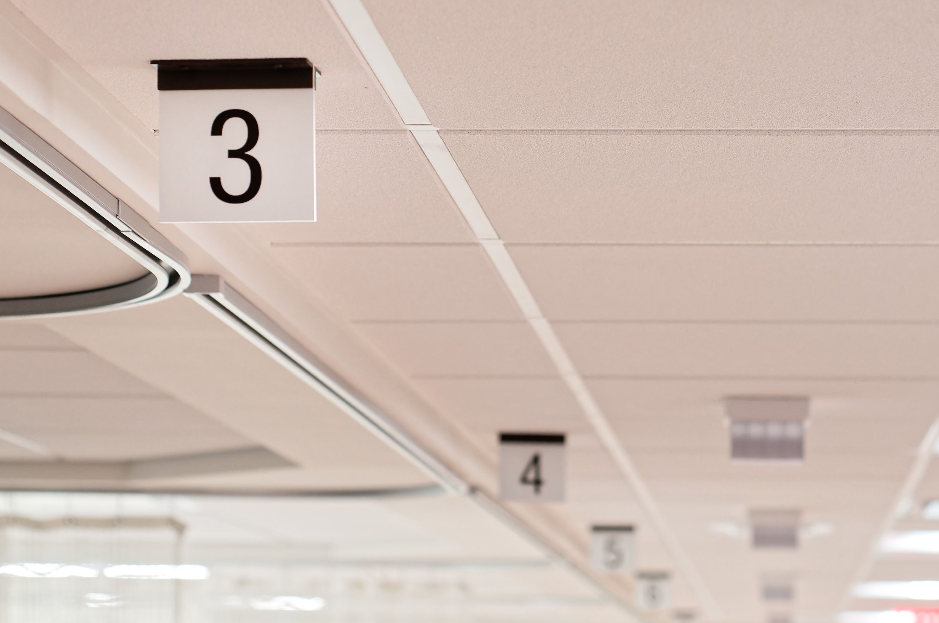 A row of numbered flag signs mounted to the ceiling identify PACU bays.