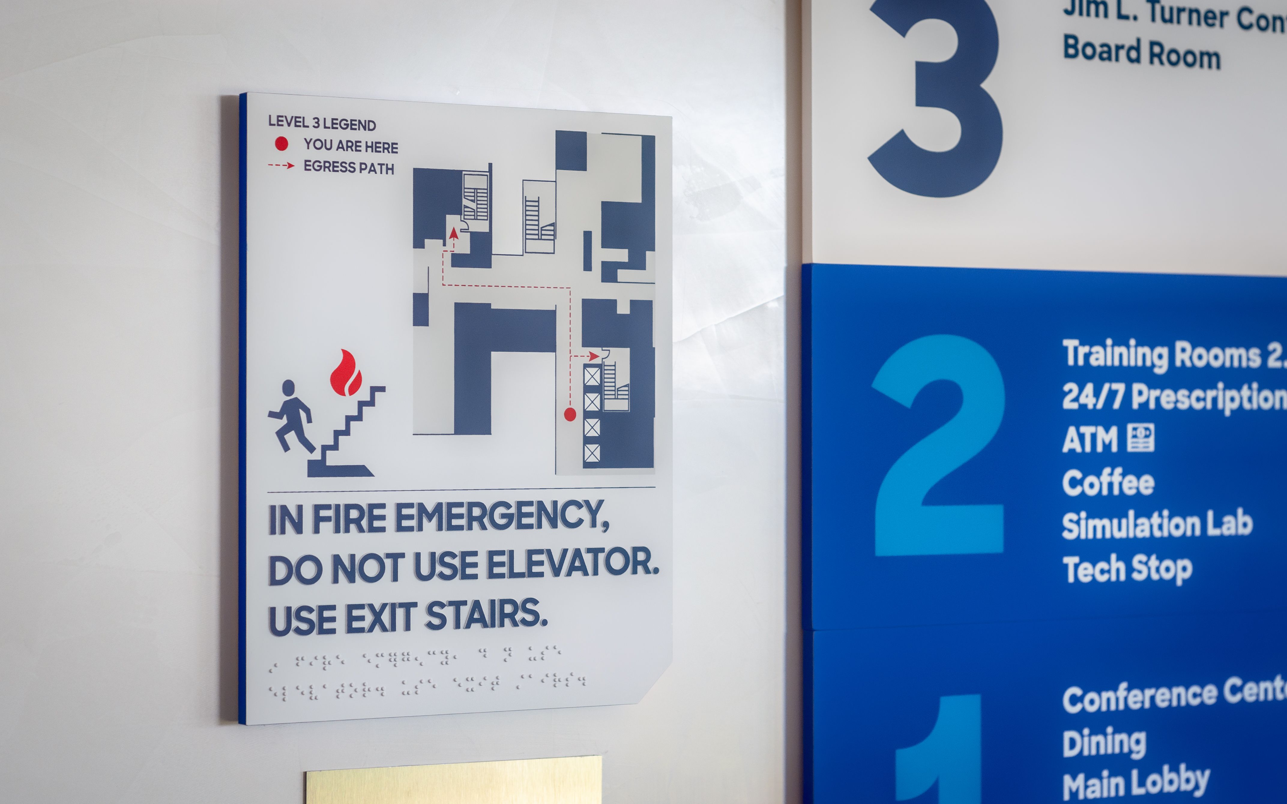 A row of numbered flag signs mounted to the ceiling identify PACU bays.