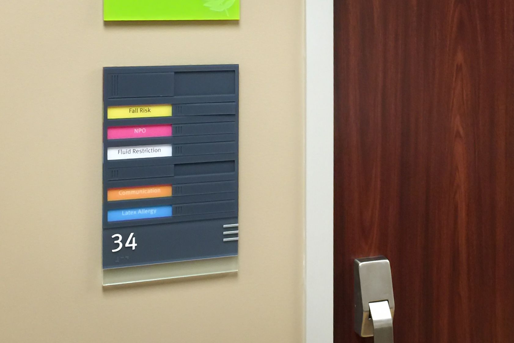 Two glow-in the dark signs are mounted inside a stairwell. One sign shows the floor and egress information and the other indicates the direction to the nearest stairs.