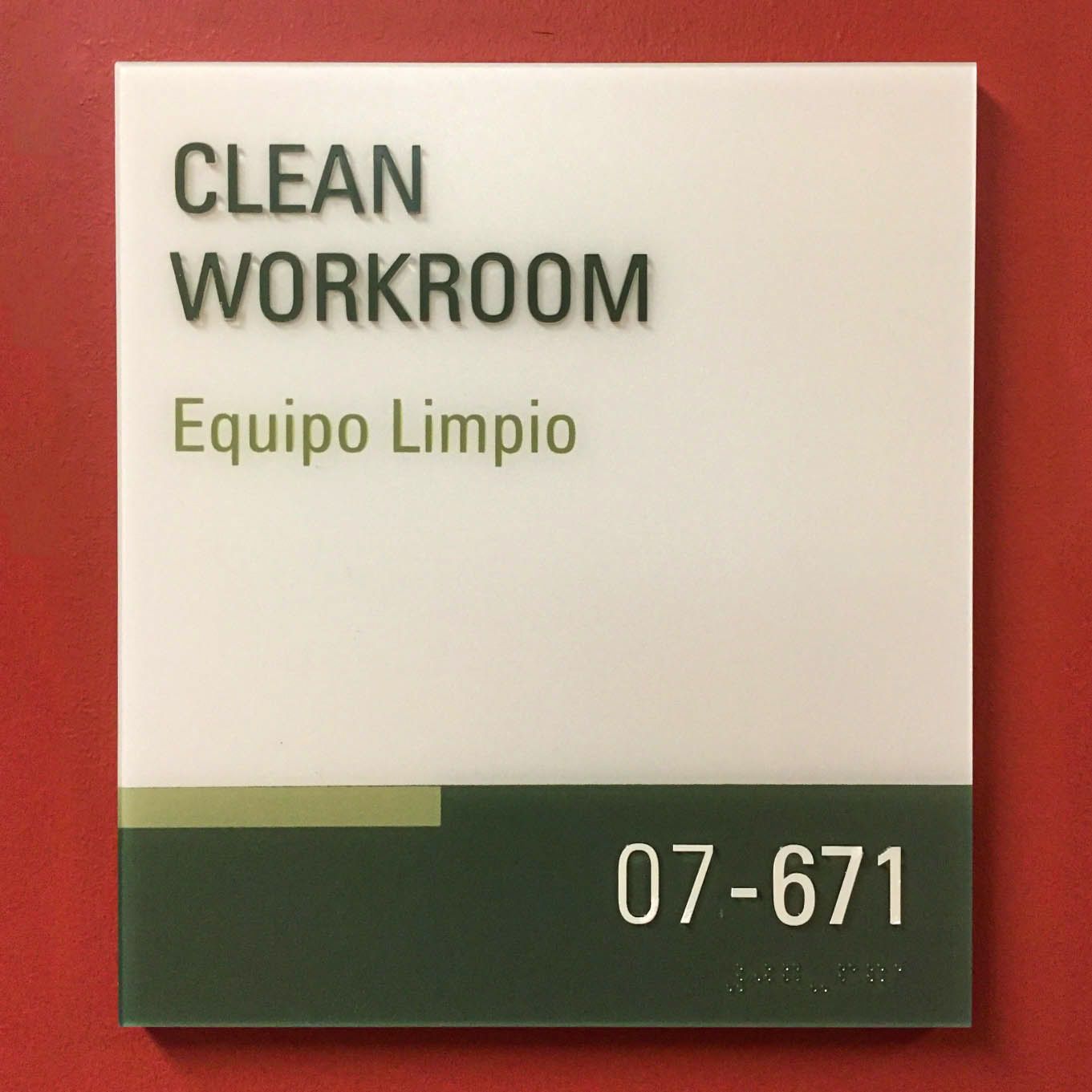 A tactile room sign labels a Clean Room in English and Spanish with raised text and braille.